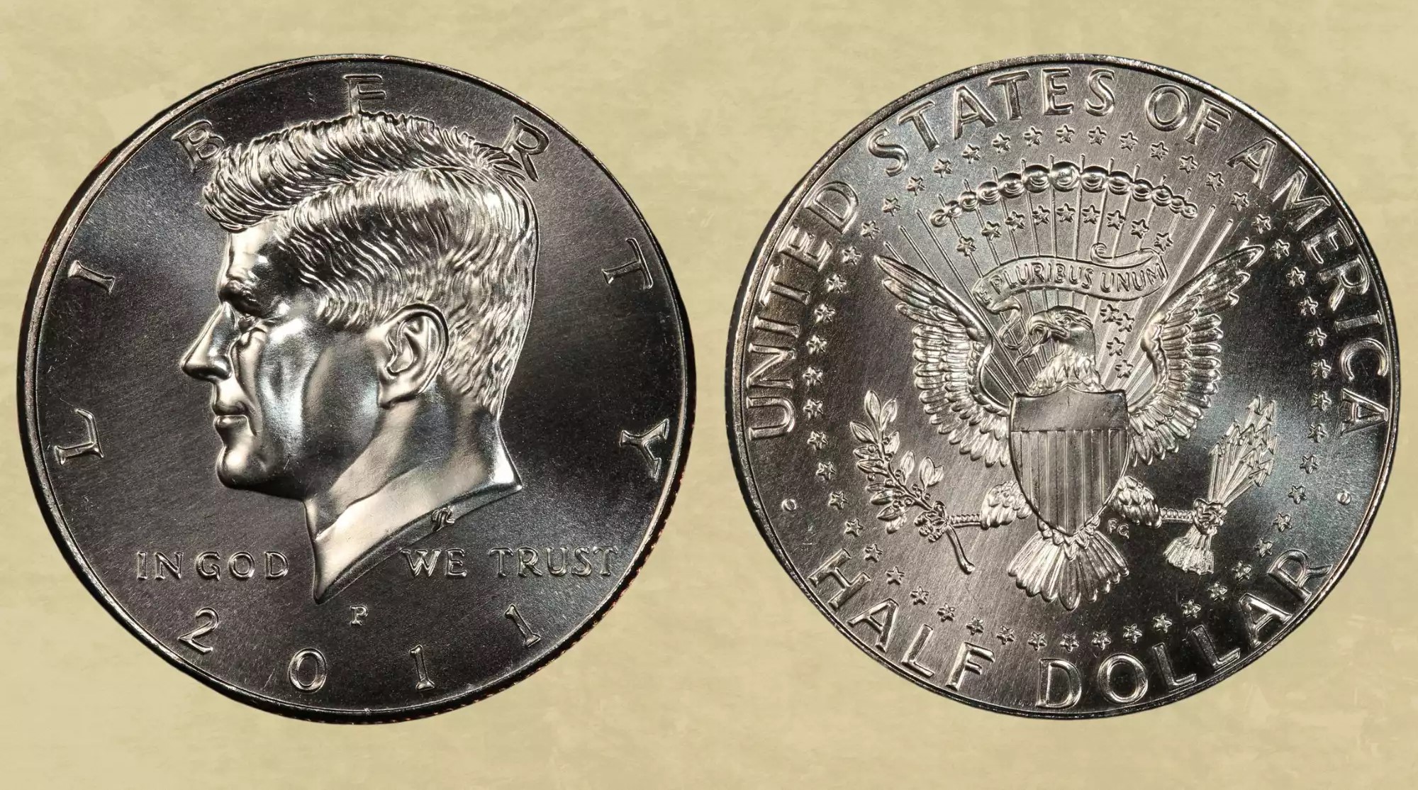 Comparison of a typical 2011-P Kennedy half dollar versus a high-grade MS69 example showing surface quality differences